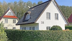 Un bâtiment blanc avec un toit noir et le numéro 38 inscrit sur son côté.