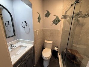 Une salle de bain avec un lavabo, des toilettes et une douche.