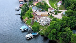 En fastighet vid sjön med en egen brygga, ett stort hus med en veranda och en skylt som visar ”Solnedgångar vid Washburn”.