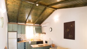 Une cuisine compacte avec un plafond en bois, un canapé et un petit coin repas.