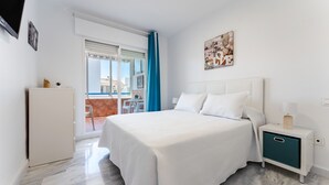 Un dormitorio con cama, mesita de noche y vistas al exterior.