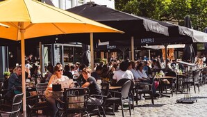 An outdoor café with outdoor seating, tables, and umbrellas. - Villa in Someren Near Golf Course (Someren)