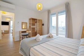 Une chambre d’hôtel avec un lit, un bureau, une armoire et une grande fenêtre.
