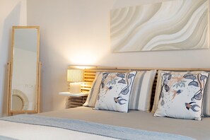 A bedroom with a bed, a bedside table with a lamp, a mirror, and two decorative pillows. - Apartment 'Deluxe 4' with Private Terrace, Wi-Fi and Air Conditioning (Jesolo)
