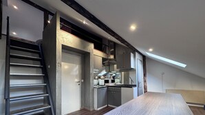 Een moderne keuken met een inbouwfornuis, kasten en een houten aanrecht.