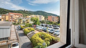 Un barrio residencial con edificios de varios pisos, un estacionamiento y una colina al fondo.