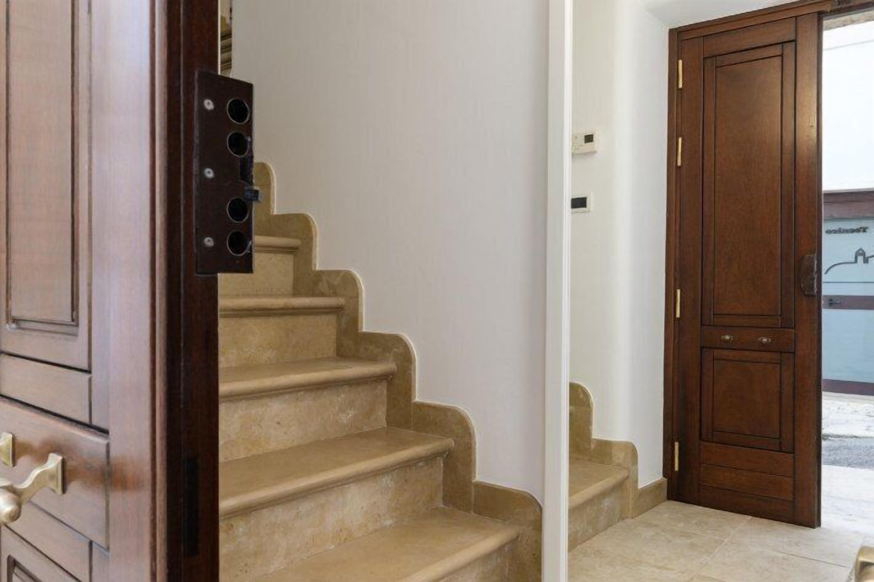 Una escalera que conduce a una puerta de madera con un picaporte de metal.