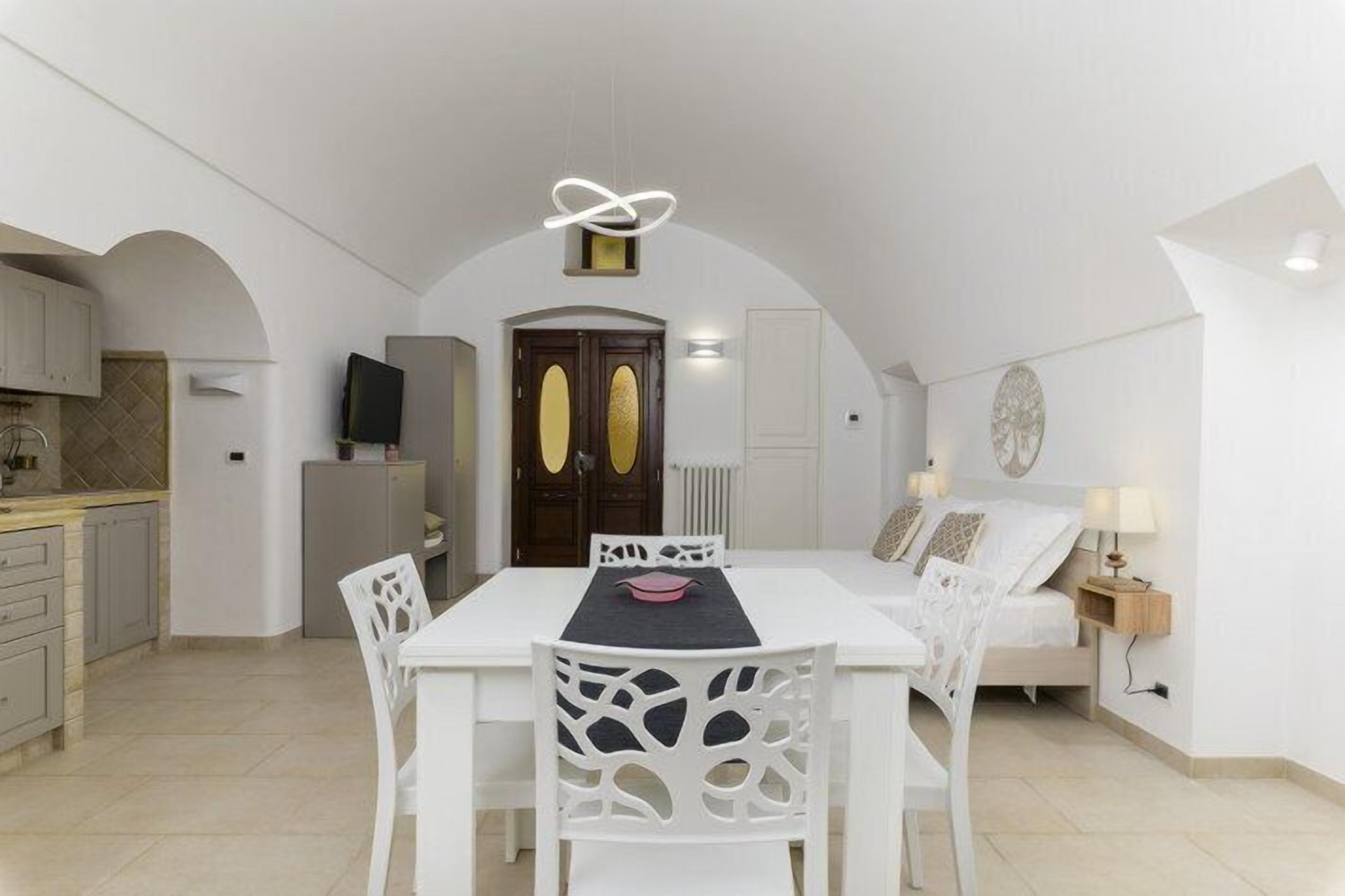 Eine kompakte, moderne Wohnung mit Essbereich, Küche und Schlafzimmer.