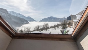 A room with a skylight, a view of snow-covered mountains, and a clear sky. - Apartment 'Les Anailles' with Mountain View, Shared Terrace and Wi-Fi (Saint-Ferréol)