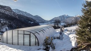 A greenhouse structure in a snowy landscape with mountains in the background. - Apartment 'Les Lutins' with Mountain View, Shared Terrace and Wi-Fi (Saint-Ferréol)