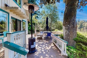 A wooden deck with outdoor furniture, a trash can, and a lamp post. - Family-friendly lakefront escape with outdoor dining, gas grill, kayaks and W/D (Lacey)