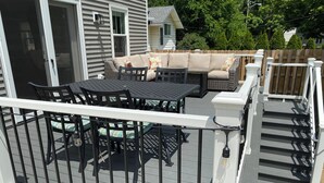 A deck with a white railing, a round table, and black chairs. - Short Walk to the Big House, Modern Spacious 3 BR + Basement Suite, 3.5 baths (Ann Arbor)