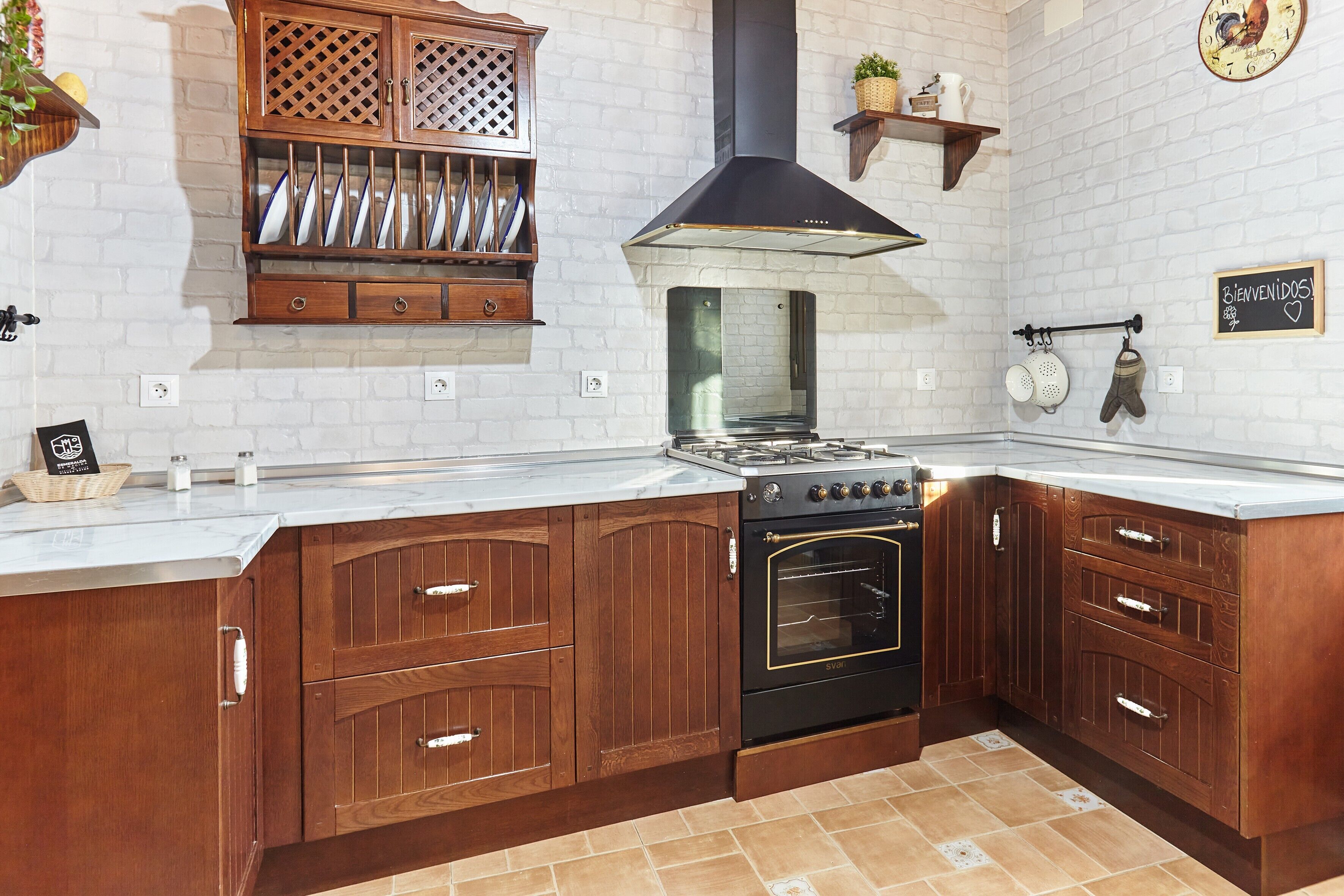 A kitchen with wooden cabinets, a stove, and a black range hood.