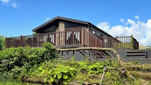 A two-story house with a balcony, surrounded by greenery and a clear blue sky. - 3 bedroom accommodation in Dollar (Dollar)