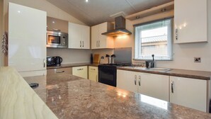 A modern kitchen with a granite countertop, stainless steel appliances, and white cabinetry. - 3 bedroom accommodation in Dollar (Dollar)