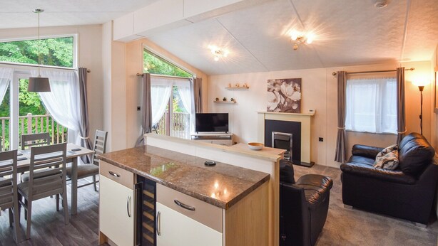 A modern kitchen with a dining area, a fireplace, and a living room with a sofa. - 3 bedroom accommodation in Dollar (Dollar)