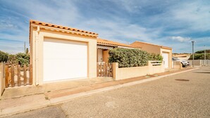 Ein Wohngebäude mit Garage, Holzzaun und Carport.