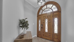A wooden front door with a glass panel and the name "ROGER" above it. - Spacious & Central Pool Home By McAuliffe Park (McAllen)