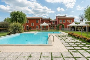 Un'area piscina con un edificio rosso sullo sfondo.