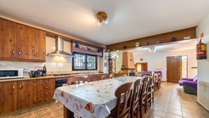 A kitchen with wooden cabinets, a microwave, and a dining table with chairs.