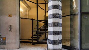 A staircase leading to an upper floor, a striped column, and a glass door. - City and the Sea by Wonderful Italy (Genoa)