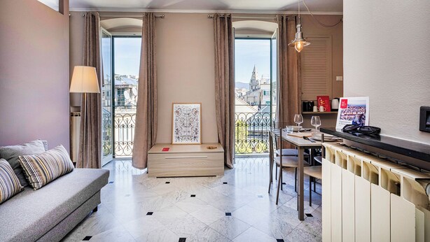A modern hotel room with a balcony, a dining area, and a sofa. - City and the Sea by Wonderful Italy (Genoa)