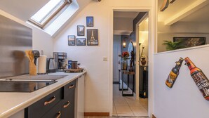Een moderne keuken met dakraam, een koffieapparaat en een aanrecht met diverse keukenbenodigdheden.