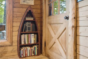 Une porte en bois ornée d’un motif géométrique et une bibliothèque remplie de livres.