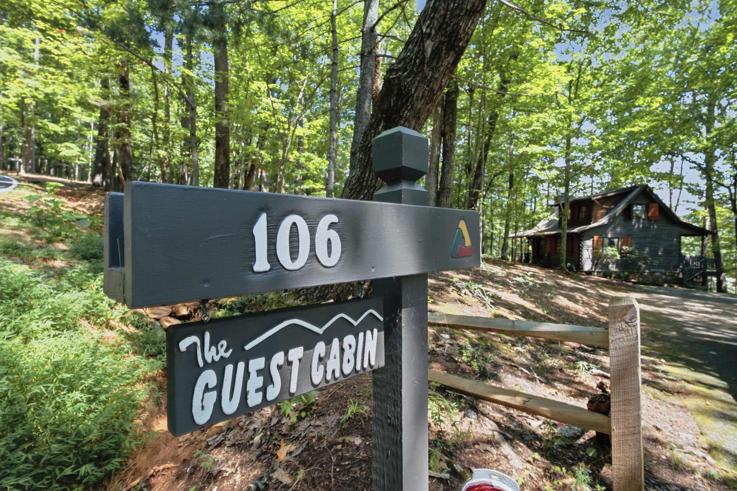 A wooden sign with the number 106 and the text 'The Guest Cabin' indicating a lodging location.