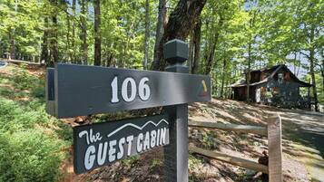 A wooden sign with the number 106 and the text 'The Guest Cabin' indicating a lodging location.