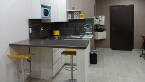 Eine moderne Küche mit Kochinsel, Barhocker, integriertem Mikrowellenherd und Spüle.