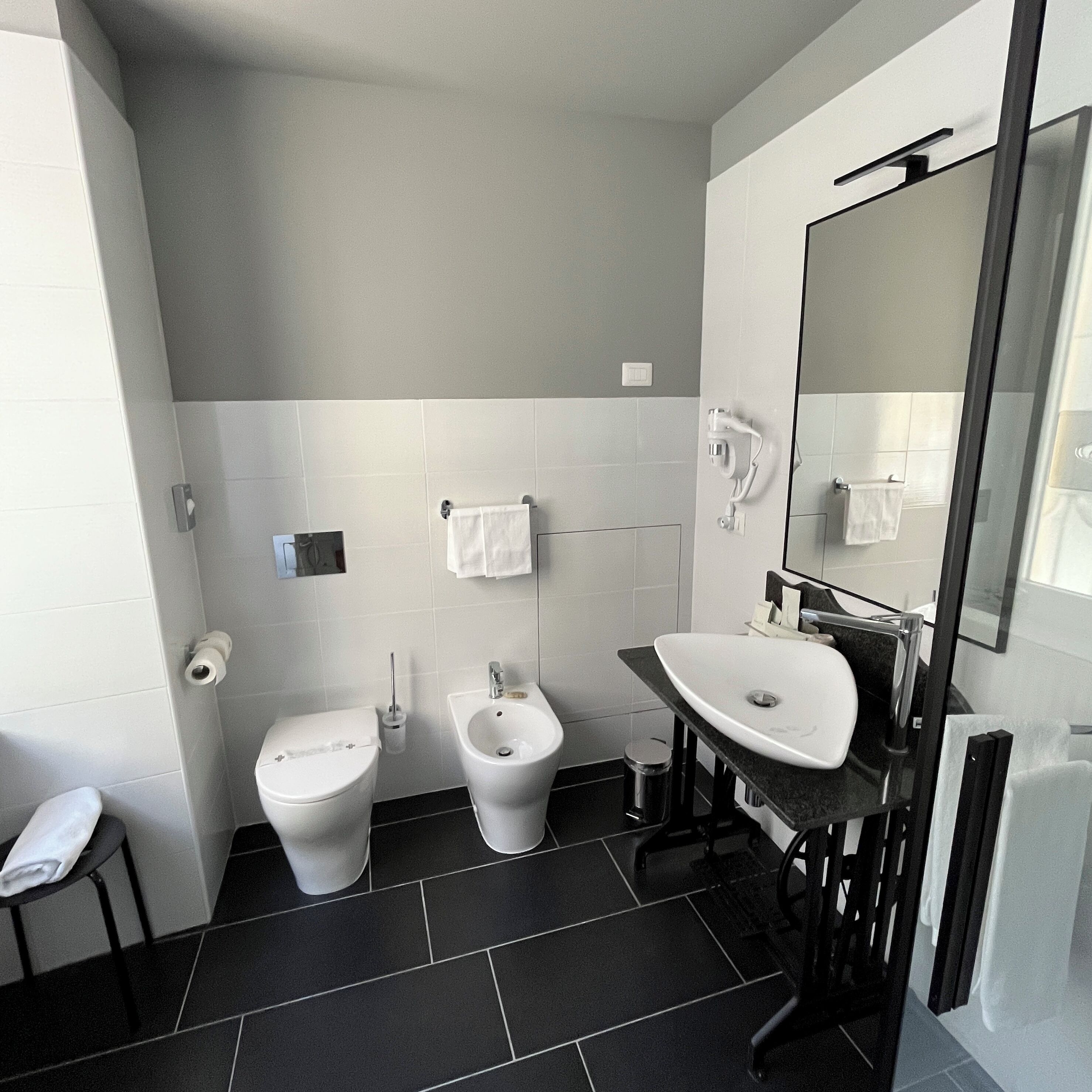 A modern bathroom with a toilet, bidet, and sink.