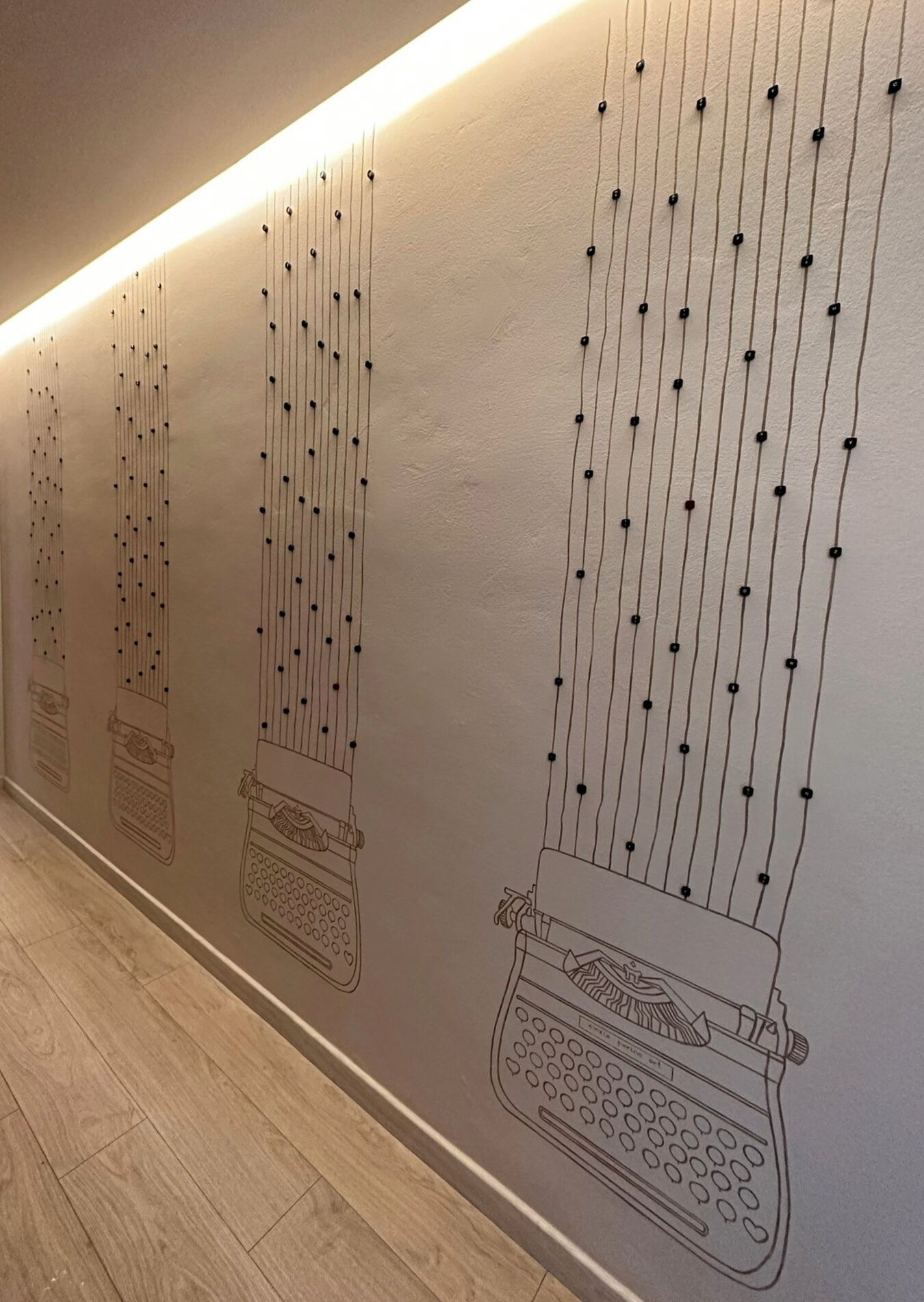 Un mur orné d’une série de lignes verticales et de points, qui évoque une guirlande de perles ou un motif décoratif.