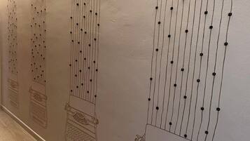 Un mur orné d’une série de lignes verticales et de points, qui évoque une guirlande de perles ou un motif décoratif.