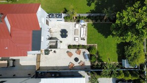An aerial view of a rooftop patio with outdoor furniture, a pool, and surrounding greenery. - A newly renovated classic Charleston home in the heart of downtown  (Charleston)