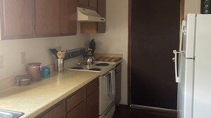 A kitchen with wooden cabinets, a stove, a sink, and a refrigerator. - Beautiful little Magnolia in Las Cruses  (Las Cruces)