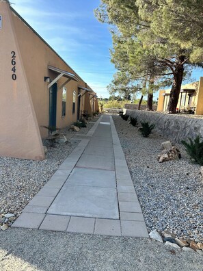 A pathway leading to a building with a number '2640' on the wall, surrounded by gravel and small plants. - Beautiful little Magnolia in Las Cruses  (Las Cruces)