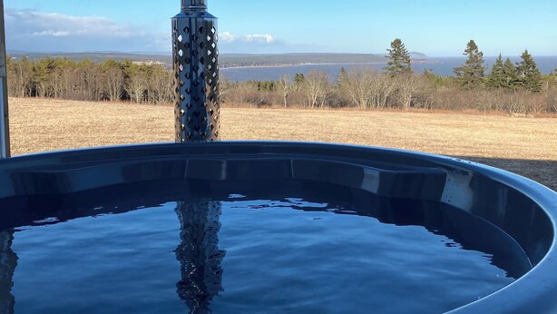 Un jacuzzi al aire libre con vistas despejadas a un lago y montañas al fondo.