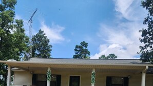 A single-story house with a front porch, a satellite dish, and a small front yard.