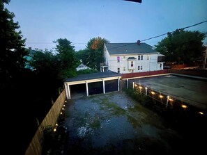 Ein zweistöckiges Haus mit Garage, überdachter Auffahrt und einem eingezäunten Garten.