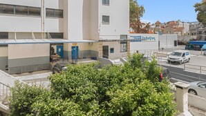 A multi-story building with a blue door, a sign reading 'Radias,' and a parking area with cars. - Apartment 'Family, Enjoy Athens, Apt 90 Cm' with Private Garden, Wi-Fi and Air Conditioning (Athina)