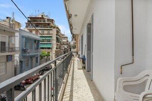A narrow balcony with a metal railing, a white chair, and a view of adjacent buildings. - Apartment 'Family, Enjoy Athens, Apt 90 Cm' with Private Garden, Wi-Fi and Air Conditioning (Athina)