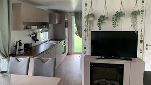 Una cocina moderna con un televisor de pantalla plana, una chimenea y plantas colgantes.