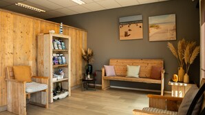 Una habitación con muebles de madera, un banco, una pequeña mesa y una estantería.