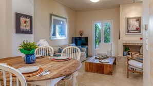 Un coin repas avec une table en bois, des chaises et une plante en pot.
