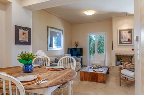 A dining area with a wooden table, chairs, and a potted plant.