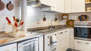 A kitchen with white cabinets, a stainless steel range hood, a double oven, and a granite countertop. - Apartment 'Appartamento Vioz' with Mountain View and Balcony (Peio)