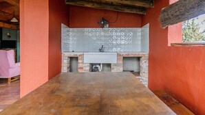 A kitchen with a wooden table, a sink, and a tiled backsplash. - Country House 'El Gallinero' with Mountain View and Private Garden (Castrejón de la Peña)