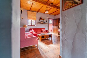 A living room with a red sofa, checkered chair, and a wooden coffee table.