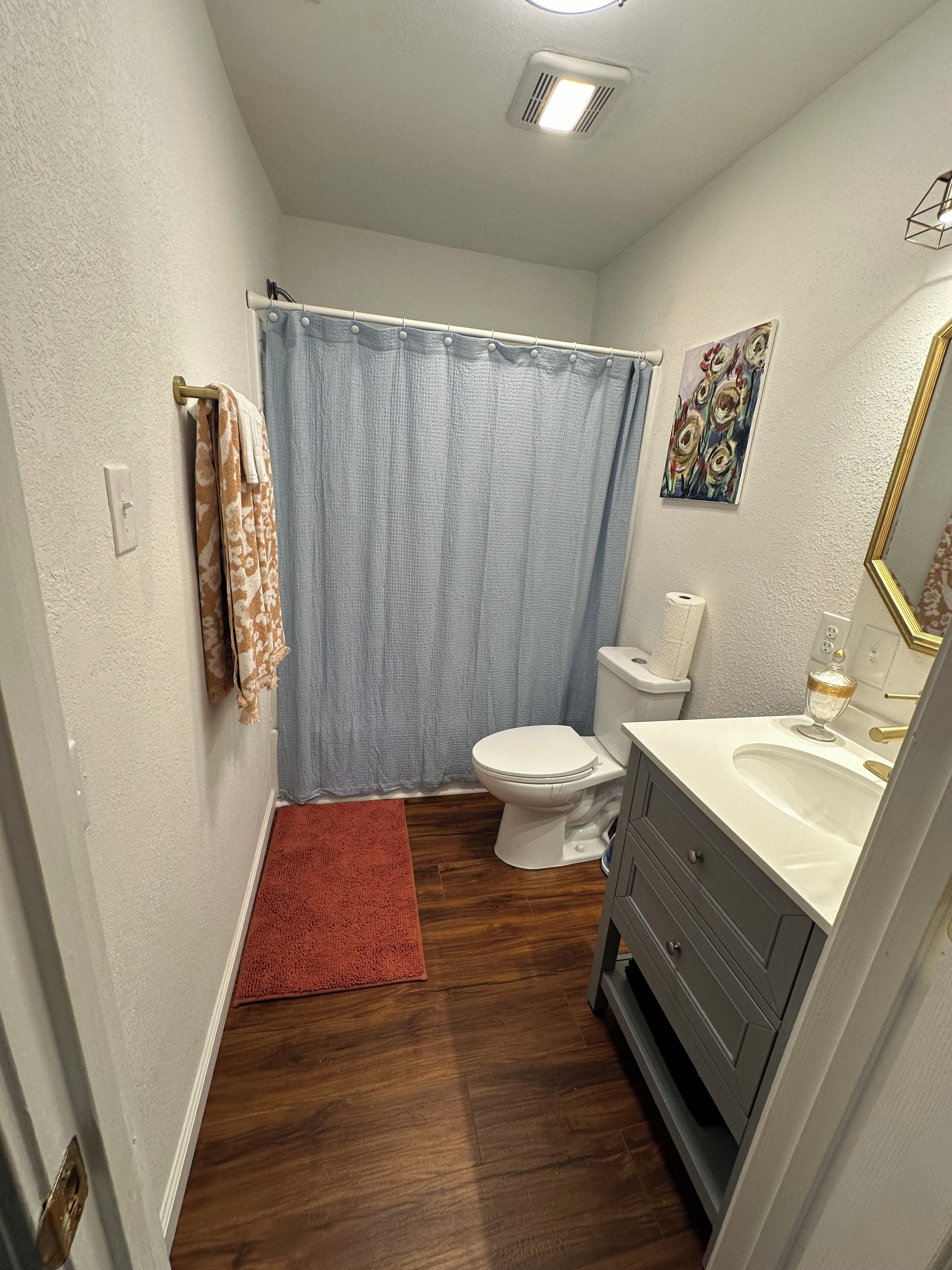 Ein Badezimmer mit Toilette, Waschbecken und Duschvorhang.